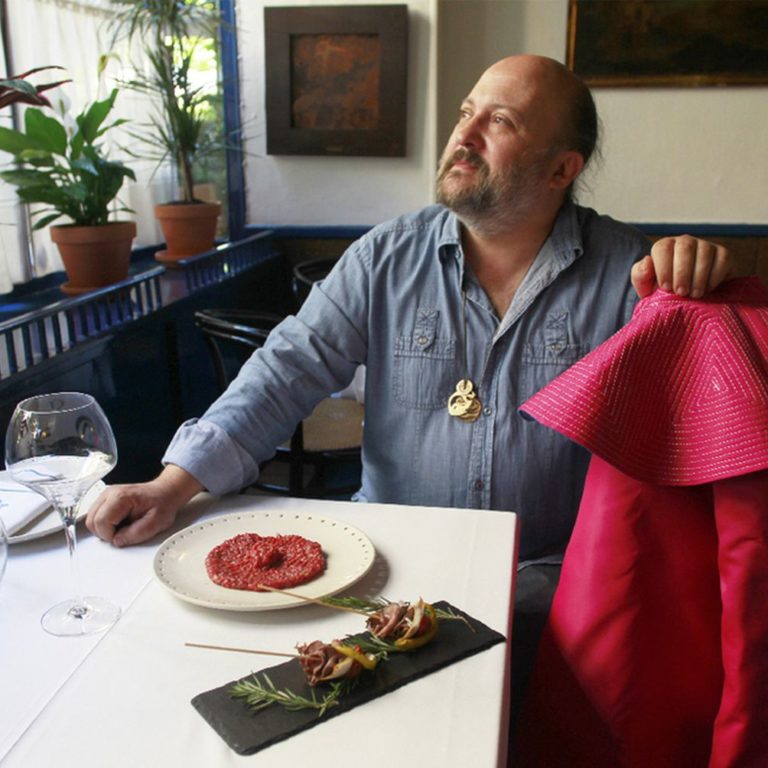 Sacha Hormaechea, en su restaurante delante de un tartar de carne de lidia y dos brochetas de lomo de res. CRISTÓBAL MANUEL